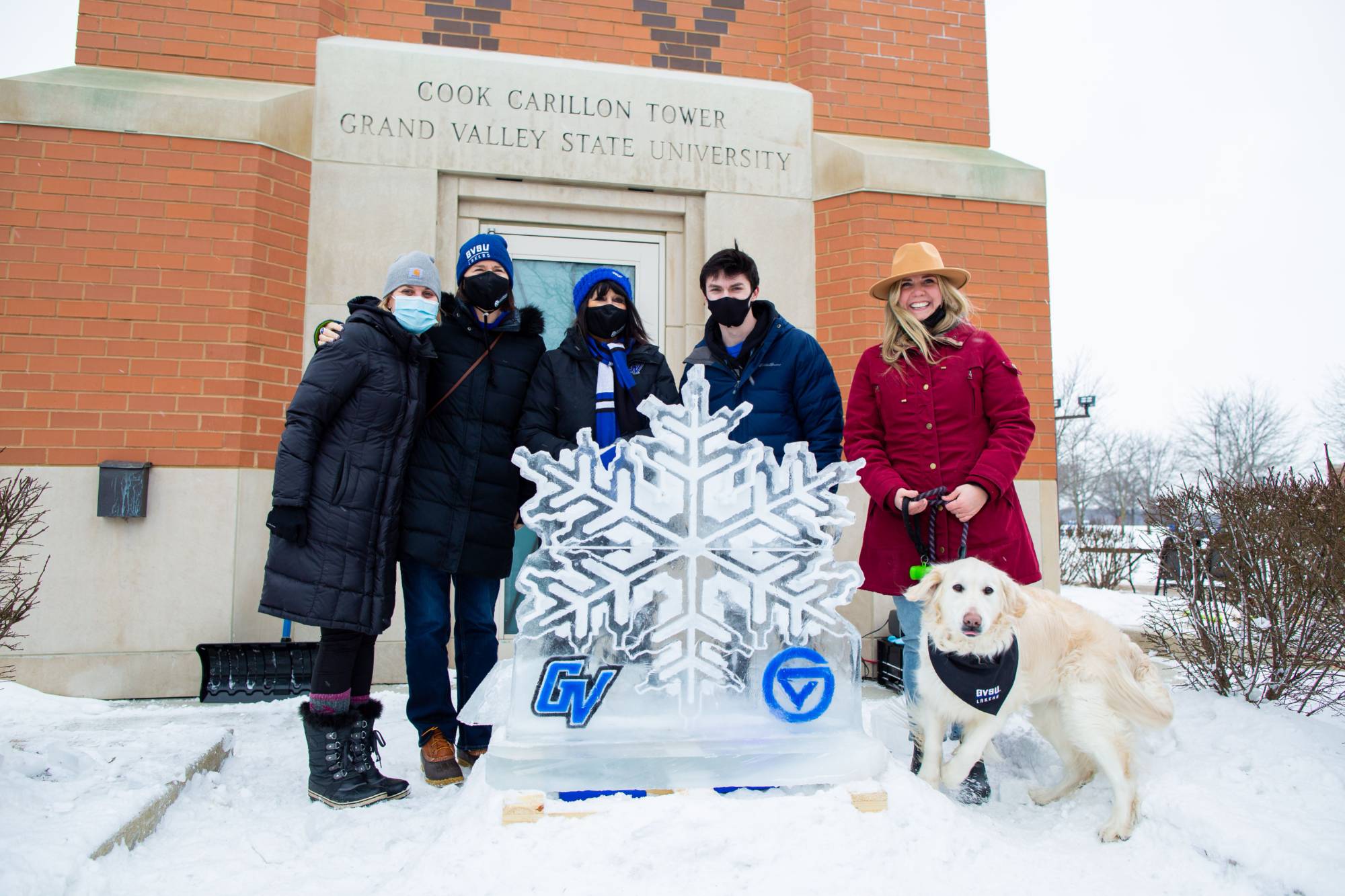 Group of 5 people standing around a snowflake ice sculpture